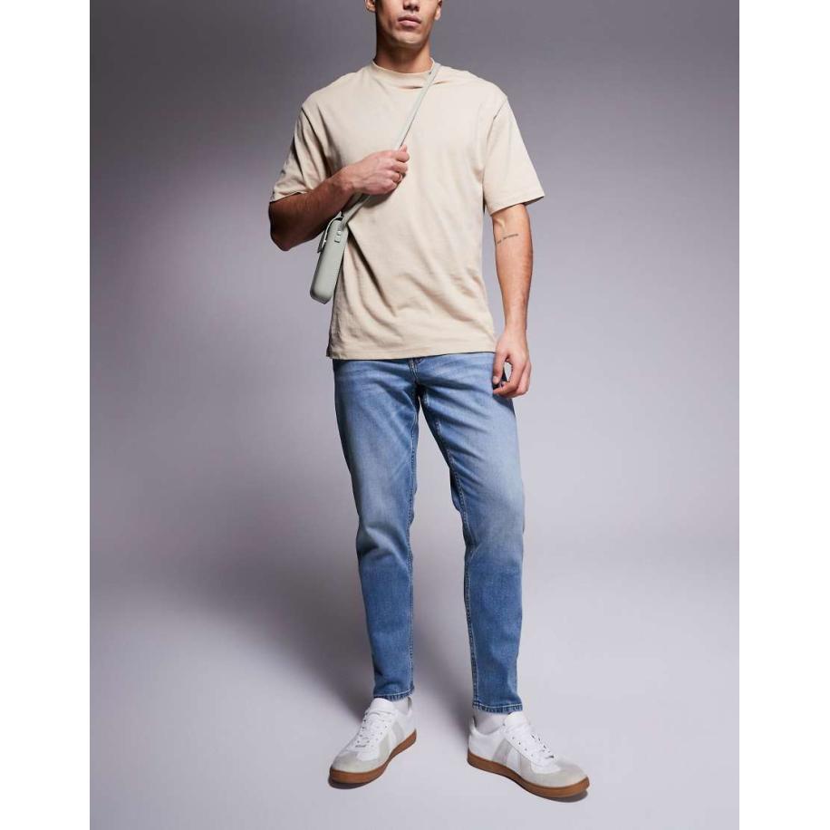 ASOS DESIGN - Toelopende jeans met stretch in mid-wash met vintage tint-Blauw Blauw
