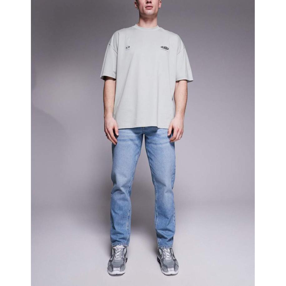 ASOS DESIGN - Jeans met smaltoelopende pasvorm in blauw met lichte wassing Blauw